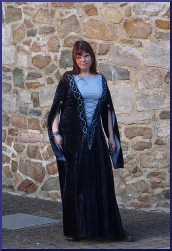 robe longue en velours bleu fonce a large echancrure et manches fendues.